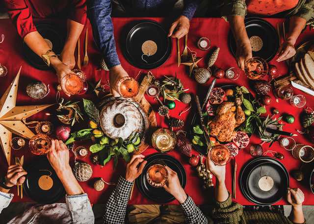 Christmas or New Year party. Flat-lay of people feasting at decorated table